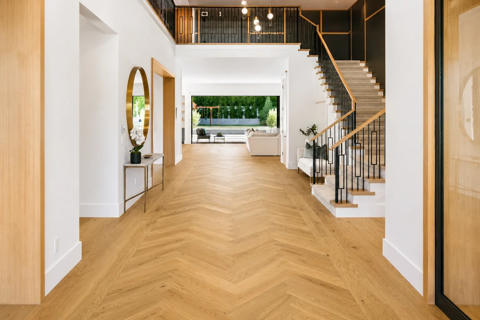 herringbone hardwood flooring in a modern entryway with staircase